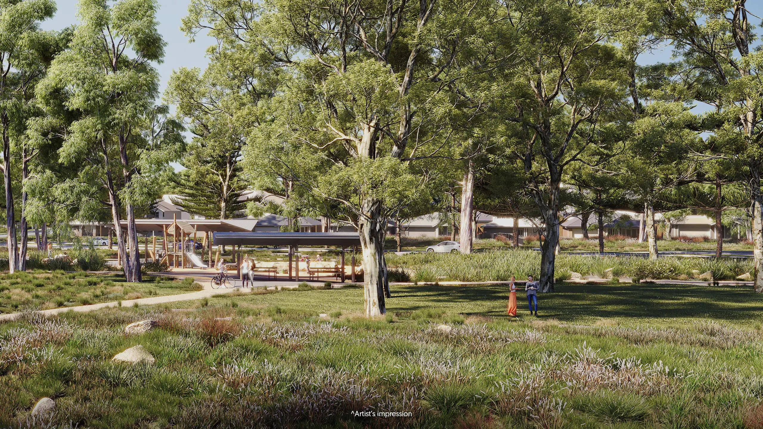 A grassy park with large trees, winding pathways, and a covered seating area. People are walking and relaxing nearby, surrounded by greenery and houses in the background.