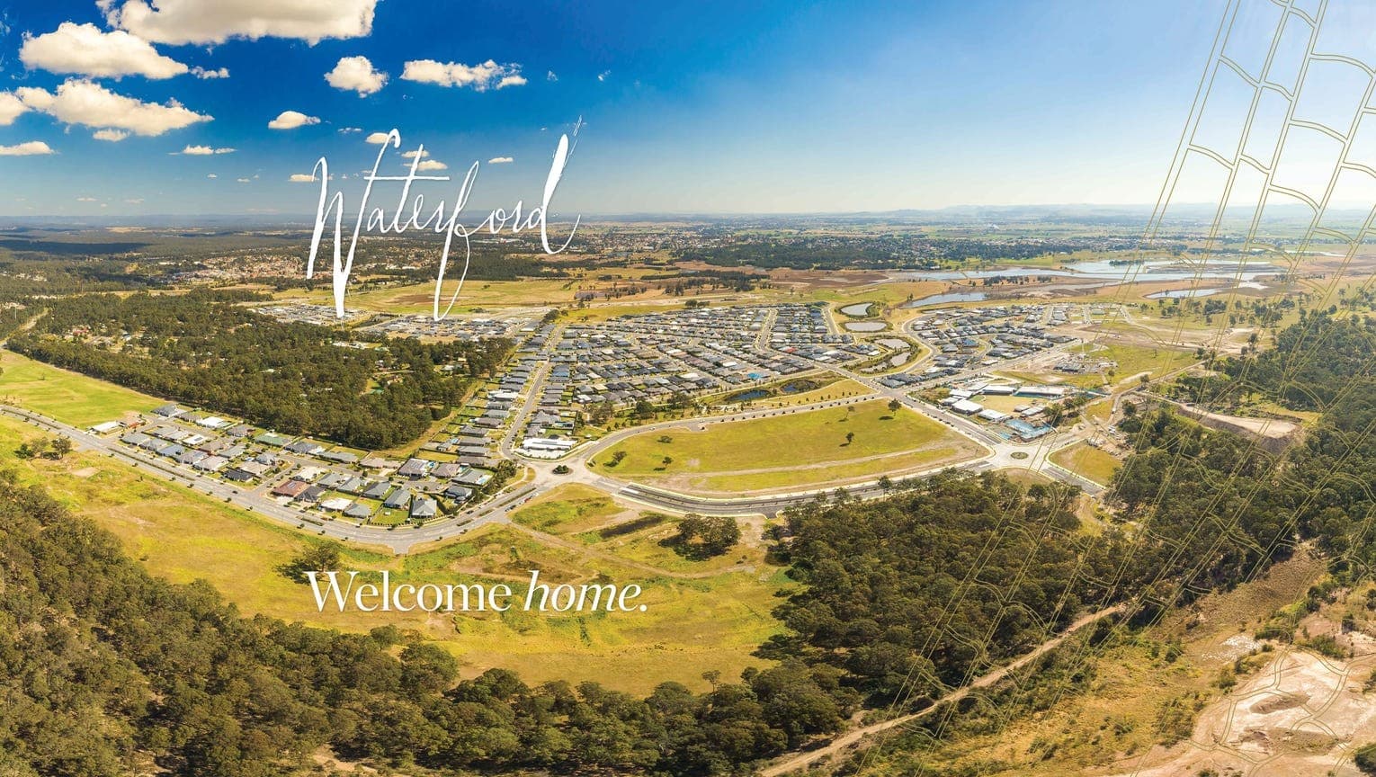 Aerial view of a suburban neighborhood surrounded by greenery, with the text Waterford and Welcome home. written on the image under a blue sky with scattered clouds.