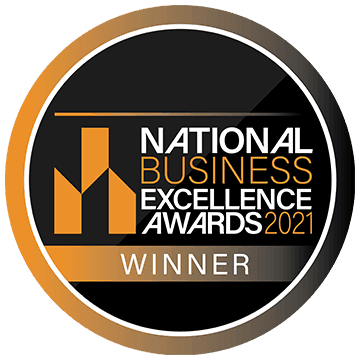A round badge with black, gold, and white colors displaying National Business Excellence Awards 2021 WINNER and a stylized geometric logo on the left side.