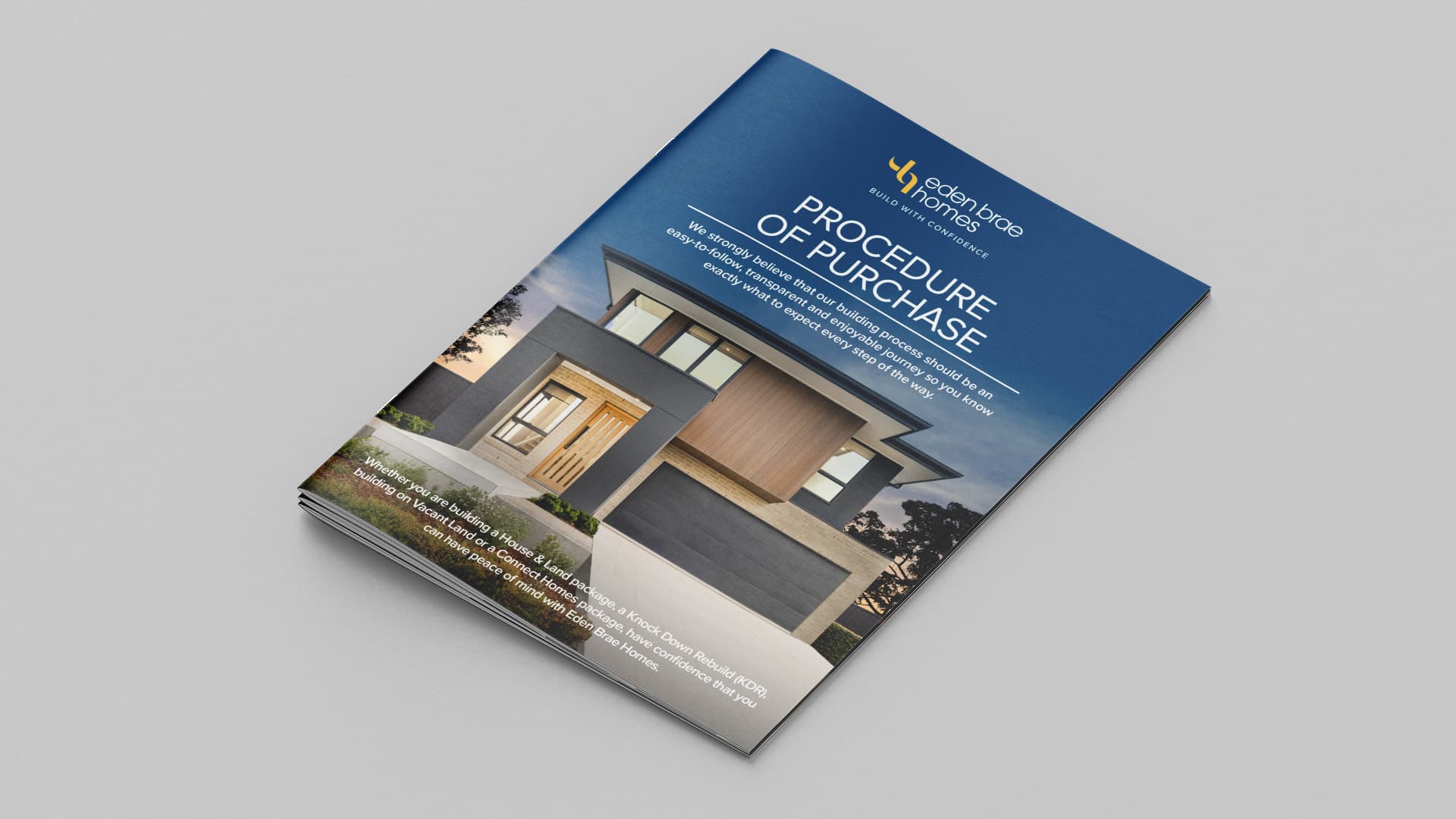A brochure titled Procedure of Purchase features a modern two-story house with large windows and a driveway on the cover. The brochure is placed on a light gray surface.