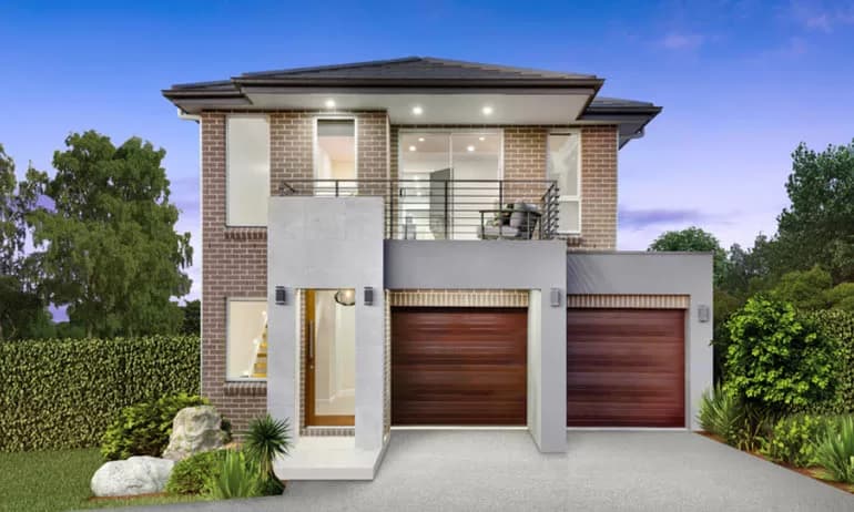 Modern two-story brick house with large windows, a balcony with glass railings, and two wooden garage doors, surrounded by greenery and a neatly landscaped yard at dusk.