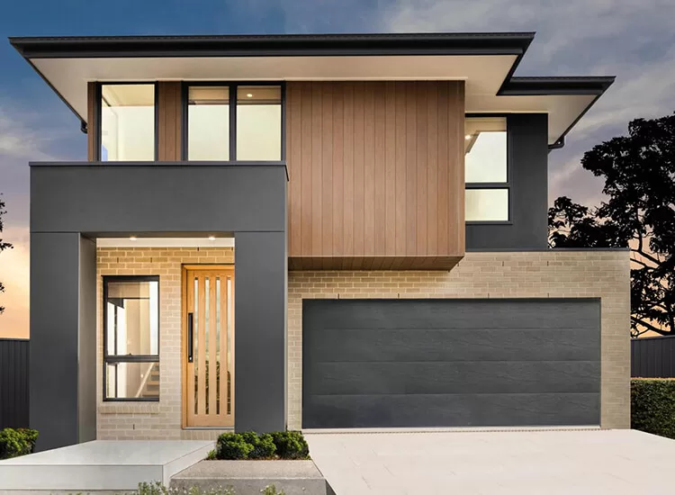 Modern two-story house with a flat roof, large windows, wood and brick accents, a light wood front door, and a double garage door. The exterior features neutral colors and minimalist landscaping.