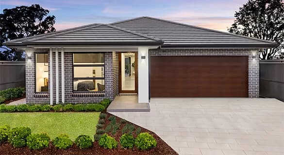 Modern single-story house with brick exterior, large windows, double wooden garage door, neatly trimmed lawn, and landscaped front garden at sunset.